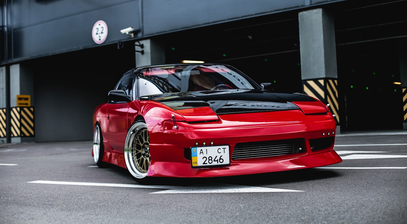 red coupe on gray concrete ground with high net worth insurance