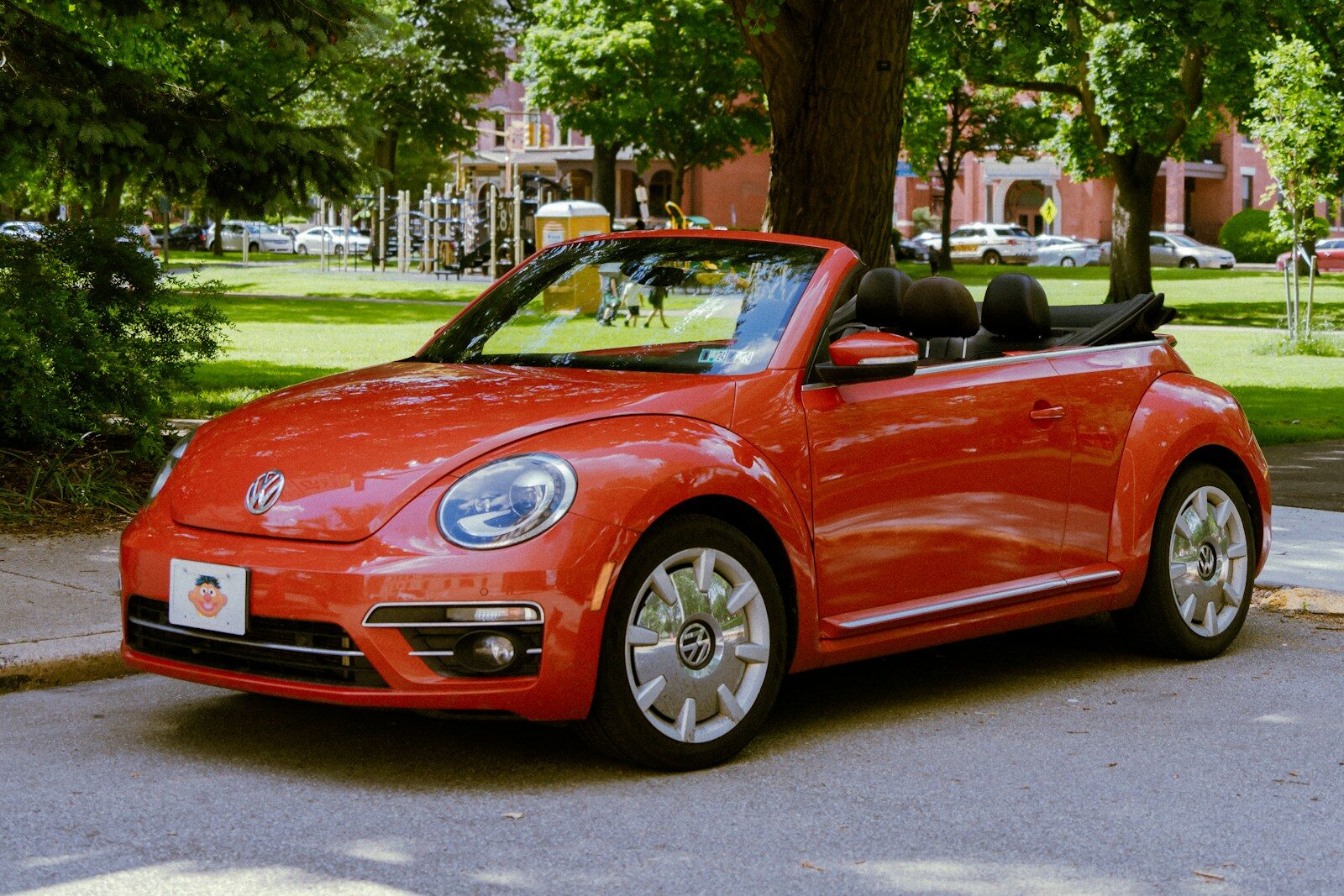 A red convertible car parked on the side of the road